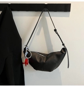 Close-up of black lychee grain hobo bag with silver zipper and elephant charm