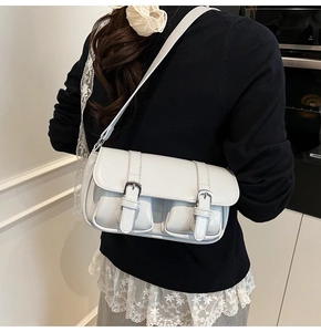 Detail of off-white retro shoulder bag with twin front pockets and metallic buckles