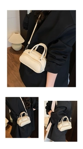 Detailed macro view of the beige lychee pattern leather shoulder bag with silver studs