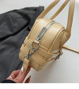 Détails de la ferrure métallique argentée et coutures sur le sac Boston en cuir PU beige