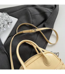 Détail de la bandoulière réglable et boucle argentée sur un sac à main crème élégant