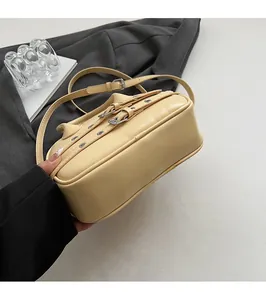 Détail du fond plat et de la texture en cuir d'un petit sac à bandoulière jaune