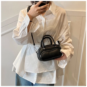 Mirror selfie showing the black lychee texture mini Boston bag with silver hardware on a model