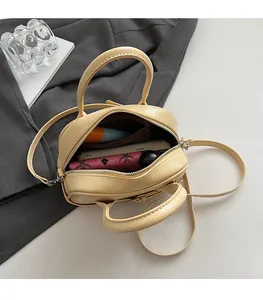 Intérieur spacieux du sac bandoulière en cuir beige montrant la capacité de rangement