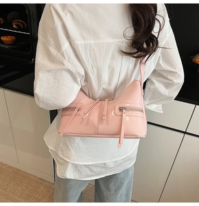 Dettaglio della borsa dumpling in pelle verniciata rosa con cerniere decorative e lucide