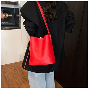Vue détaillée du sac seau rouge en cuir grainé avec fermoir sphérique argenté élégant