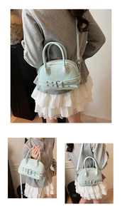 Détail du sac à main vert menthe avec double boucle de ceinture et finitions argentées