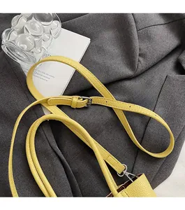 Detail of yellow lychee texture leather strap with silver metal adjustable buckle