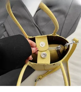 Detail of yellow lychee leather bucket bag showing magnetic closure and interior liner