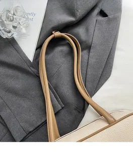 Detail of soft brown leather shoulder straps and woven fabric on a designer tote bag