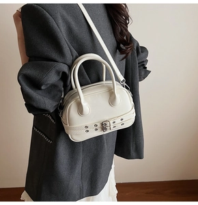 Sac Boston en cuir blanc cassé avec ceinture à œillets métalliques et bandoulière