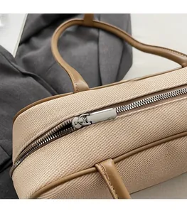 Close-up of smooth metal zipper and leather handle on denim canvas bowling bag