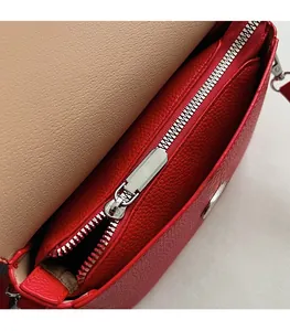 Detail of red lychee grain leather bag with premium silver metal zipper and inner lining