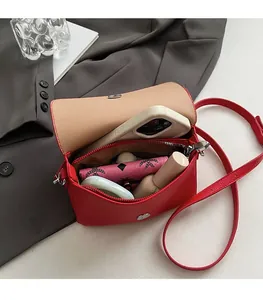 Interior detail of red litchi leather shoulder bag showing capacity for phone and makeup