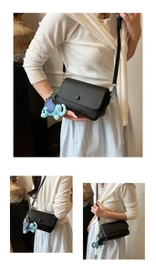 Détail du sac bandoulière en cuir grainé noir avec un charmant pendentif éléphant