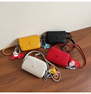 Detailed view of four minimalist lychee texture leather shoulder bags with elephant charms