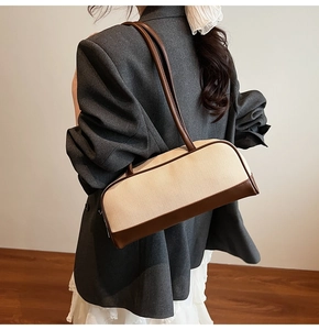 Detail of woven texture contrast with premium brown leather trim on the shoulder bag