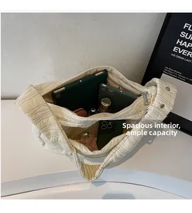 Spacious interior of beige quilted tote bag showing storage for tablet and essentials