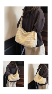 Detail of off-white wave-quilted tote bag featuring metallic plate on a retro wooden staircase