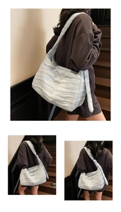 Close-up of light blue quilted tote bag showing wave stitching and nylon texture