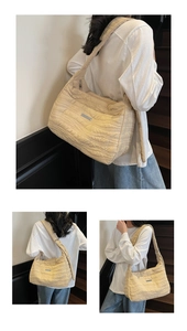 Detail of beige quilted shoulder bag with water ripple texture and adjustable strap
