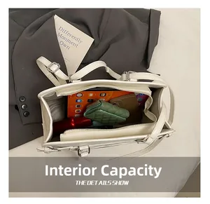 Internal capacity of large white faux leather tote bag showing tablet and accessories