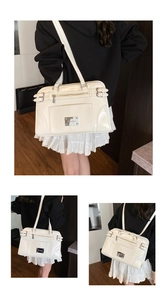 Detail view of white vintage faux leather handbag with metal logo and side buckles