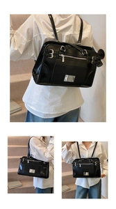 Close-up of glossy black leather handbag with silver zippers and metal hardware details