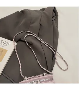 Dettaglio della borsa a scatola trapuntata rosa chiaro con zip argento e tracolla a catena