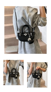 Detail of black lychee grain leather saddle bag with silver buckle and heart charm