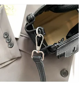 Detailed macro of black pebbled leather texture and polished silver metal hardware