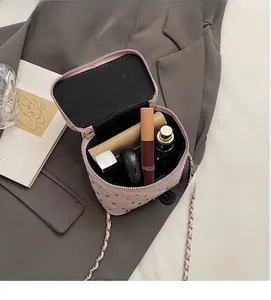 Dettaglio interno della borsa rosa trapuntata con borchie e spazio per cosmetici