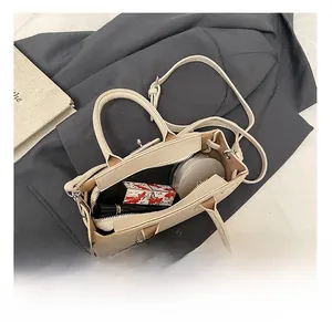 Internal view of cream leather crescent bag showing storage space for makeup and essentials