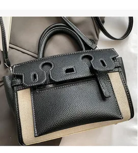 Detail of contrast stitching on leather and canvas bucket bag with removable strap