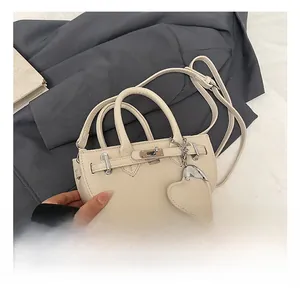 Detail of off-white lychee pattern handbag with metal lock and heart charm