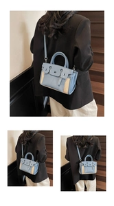 Detail view of contrast stitching and metal bottom studs on this stylish crossbody bag