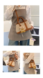 Detail of canvas bucket bag with brown leather trim and cute teddy bear charm accessory