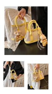 Detail of beige canvas and yellow leather patchwork bucket bags with bear charms
