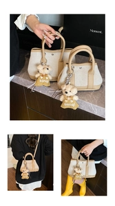 Detail of canvas bucket bag with leather trim and a cute teddy bear charm pendant