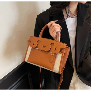 Detail of the chic contrast canvas and brown leather kelly bag with silver hardware
