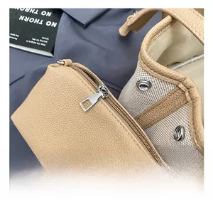 Macro detail of lychee grain leather mini pouch and canvas contrast stitching handbag