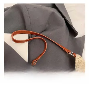 Detail showing the brown leather handle and woven mesh texture of the tote bag