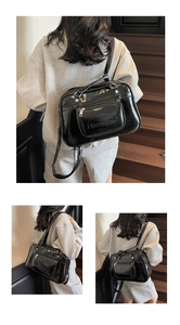 Detail of glossy black patent leather bag with embossed Notonoto logo and metal zipper pocket