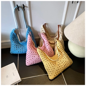 Detail of four colorful handmade crochet tote bags in blue, pink, white, and yellow