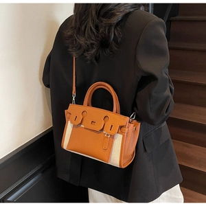 Chic brown lychee leather and beige canvas handbag shown in a lifestyle street setting