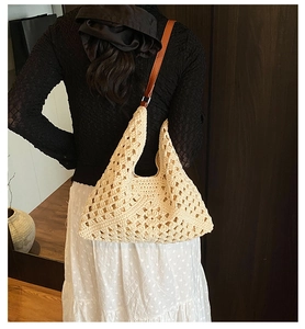 Detail of hollow-out crochet beach tote with premium brown leather shoulder straps