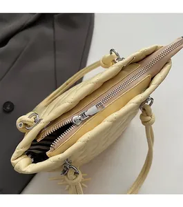 Gros plan du sac cabas matelassé beige avec fermeture éclair argentée fluide