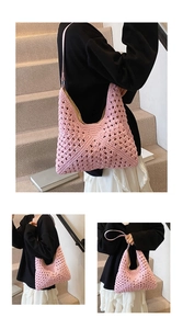 Pink hand-woven crochet hobo bag with geometric cutout patterns and soft shoulder straps
