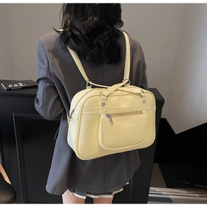 Close-up of yellow PU leather backpack with Noronoro logo shown on a model's back