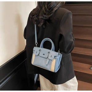 Detail of blue lychee leather and beige woven fabric contrast on the Kelly bag
